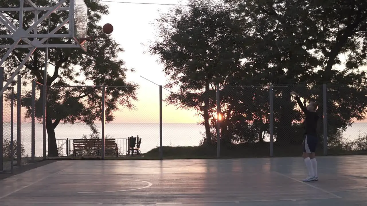 Stedicam Footage From The Side Of A Young Girl Make A Shot To The Basketball Net