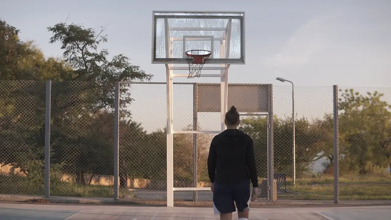 Young Female Basketball Player Exercising And Practicing Ball Handling Skill On Court