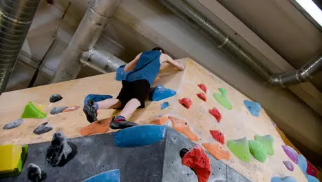 Teenage boy bouldering indoors