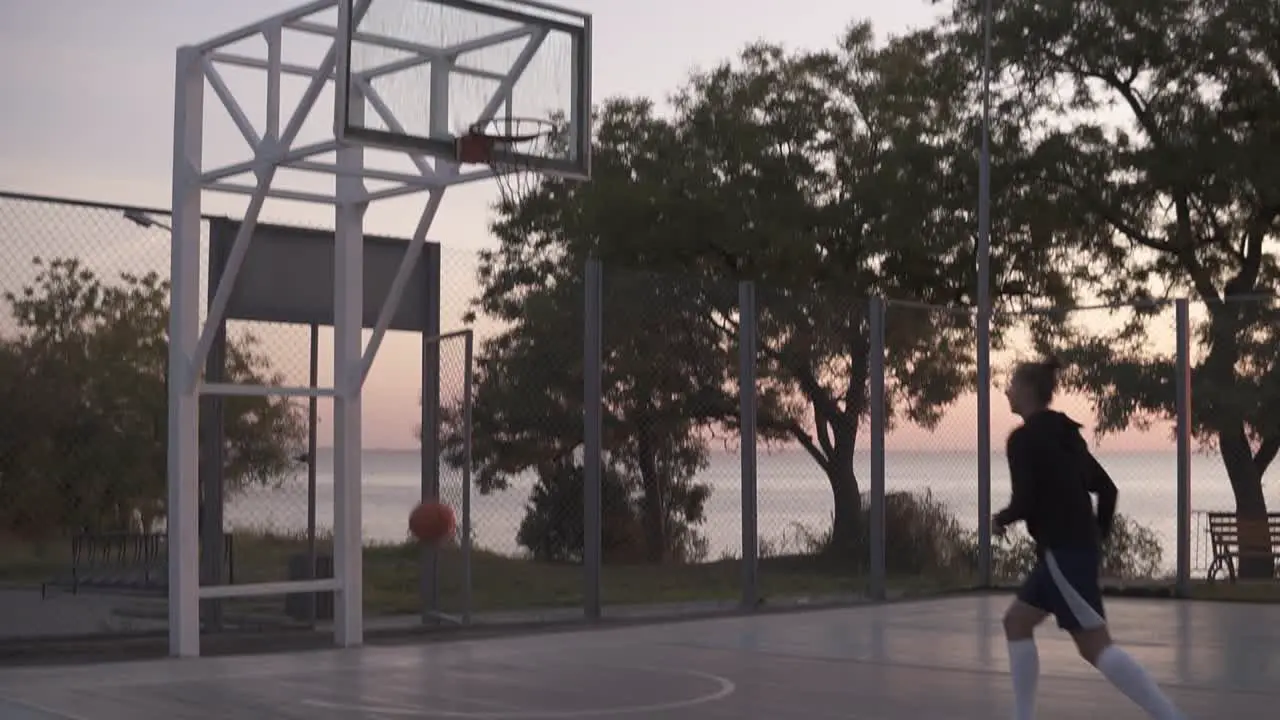 Handhelded Footage Of Young Girl In Shorts And White Golf Socks Make A Shot To The Basketball Net