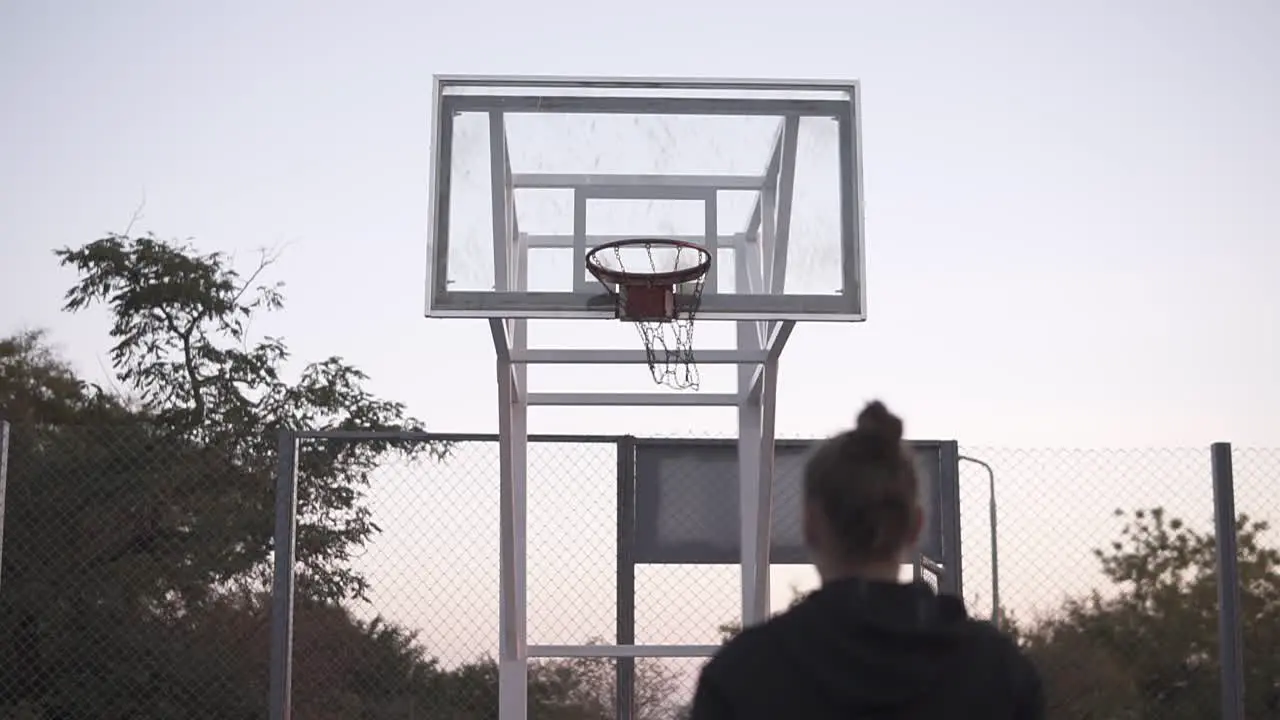 Stedicam Footage From The Backside Young Girl Make A Shot To The Basketball Net