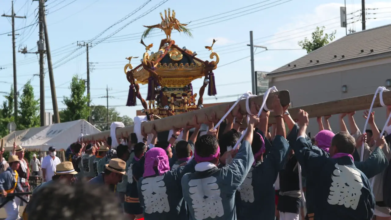 Japanese people raise mikoshi portable shrine before taking a break in local neighbourhood matsuri summer festival