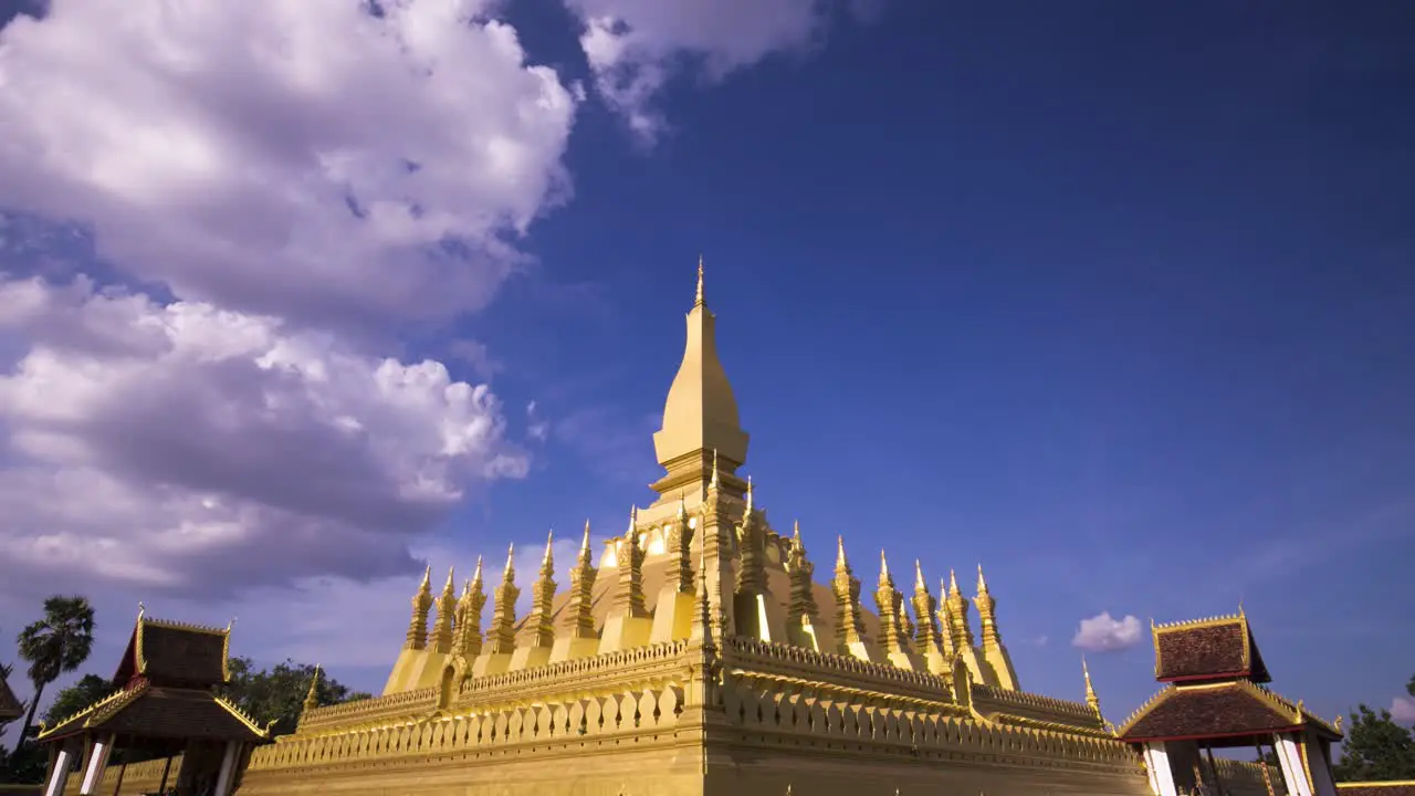 Pha That Luang with fluffy clouds and blue sky