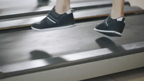 Closeup feet running back on treadmill in fitness gym