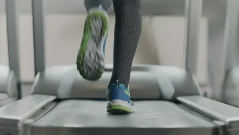 Closeup athletic feet running on running machine in fitness gym