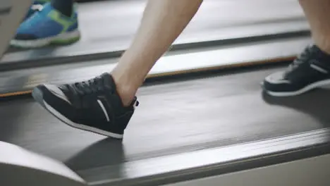 Closeup feet walking on treadmill in fitness gym slowly