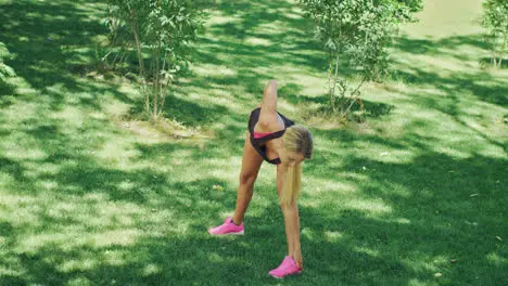 Sport woman doing stretching exercise during workout in summer park Fit woman