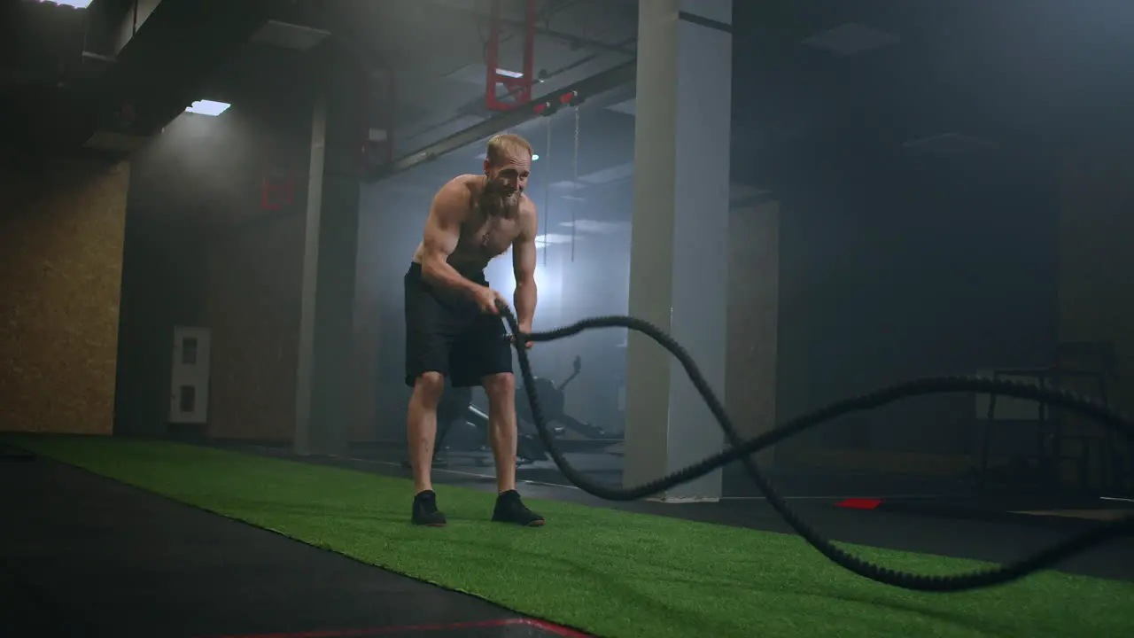 fitness athletes training using battle ropes intense workout exercise challenge in gym enjoying healthy bodybuilding endurance practice lifestyle slow motion