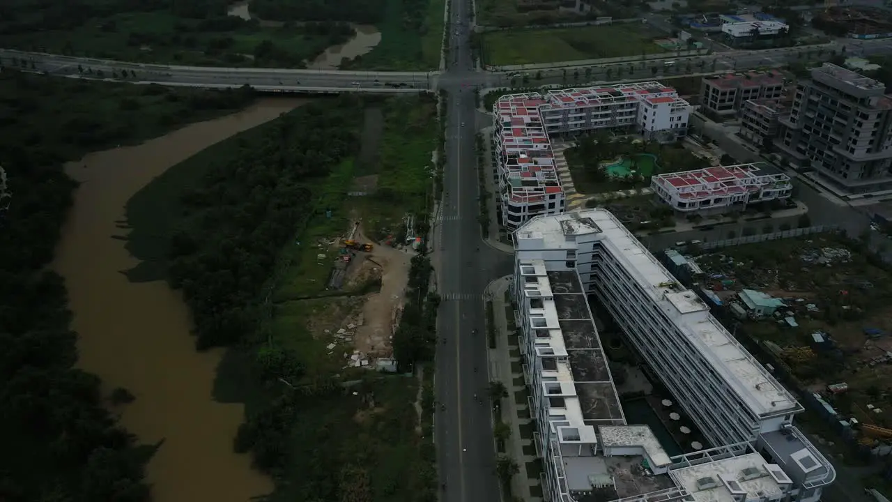 Fly in over new development wetlands and roads revealing river and city skyline view with high rise towers in early morning