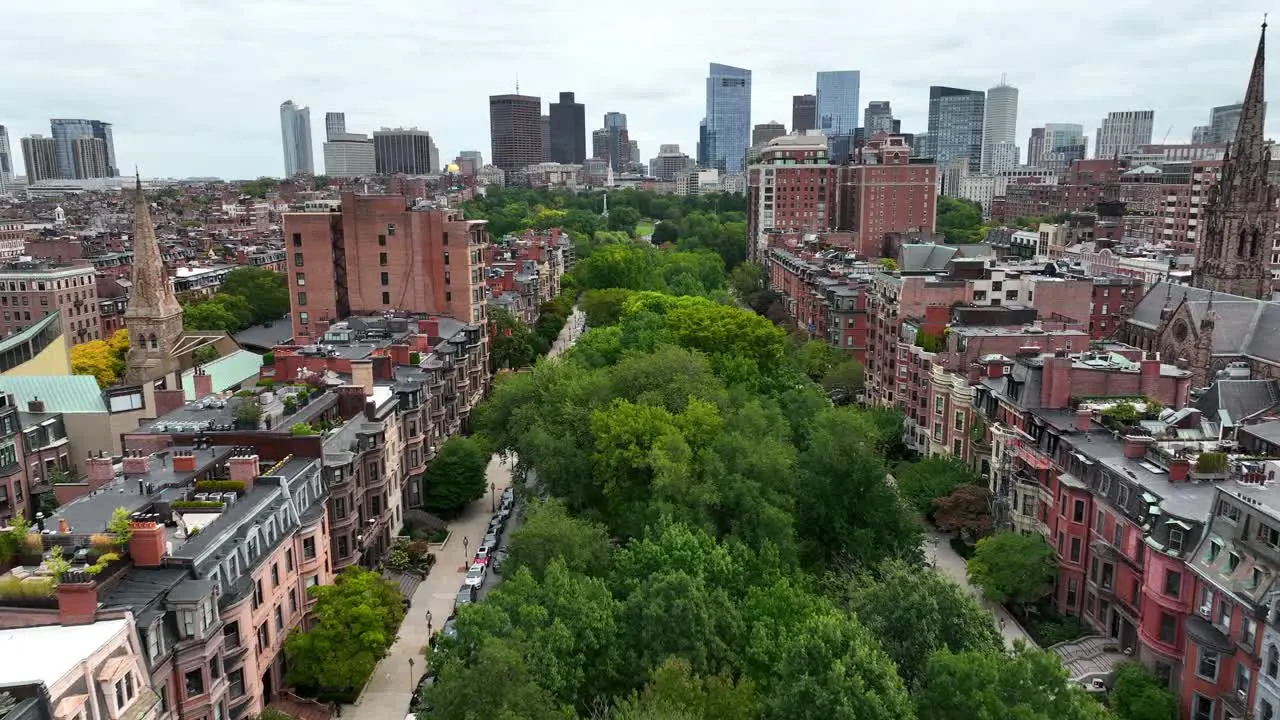 Aerial dolly forward over green park trees in suburb of Boston MA