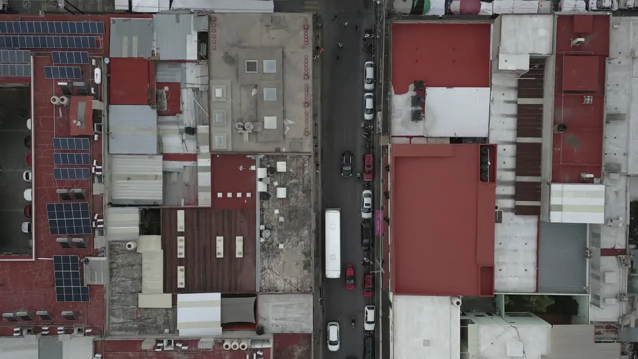 Straight down aerial of vehicles on narrow street in Oaxaca Mexico