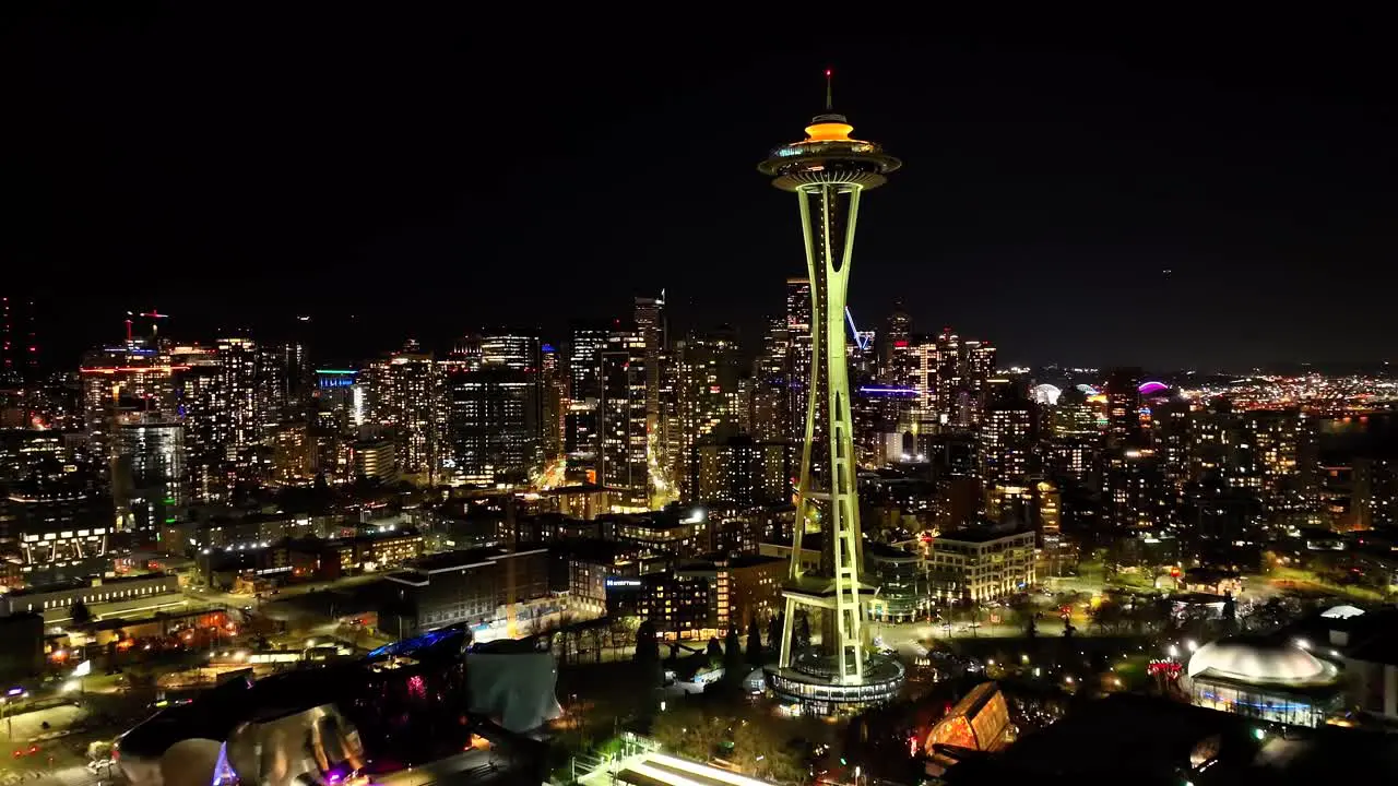 Establishing aerial of Space Needle over illuminated city in Seattle at night