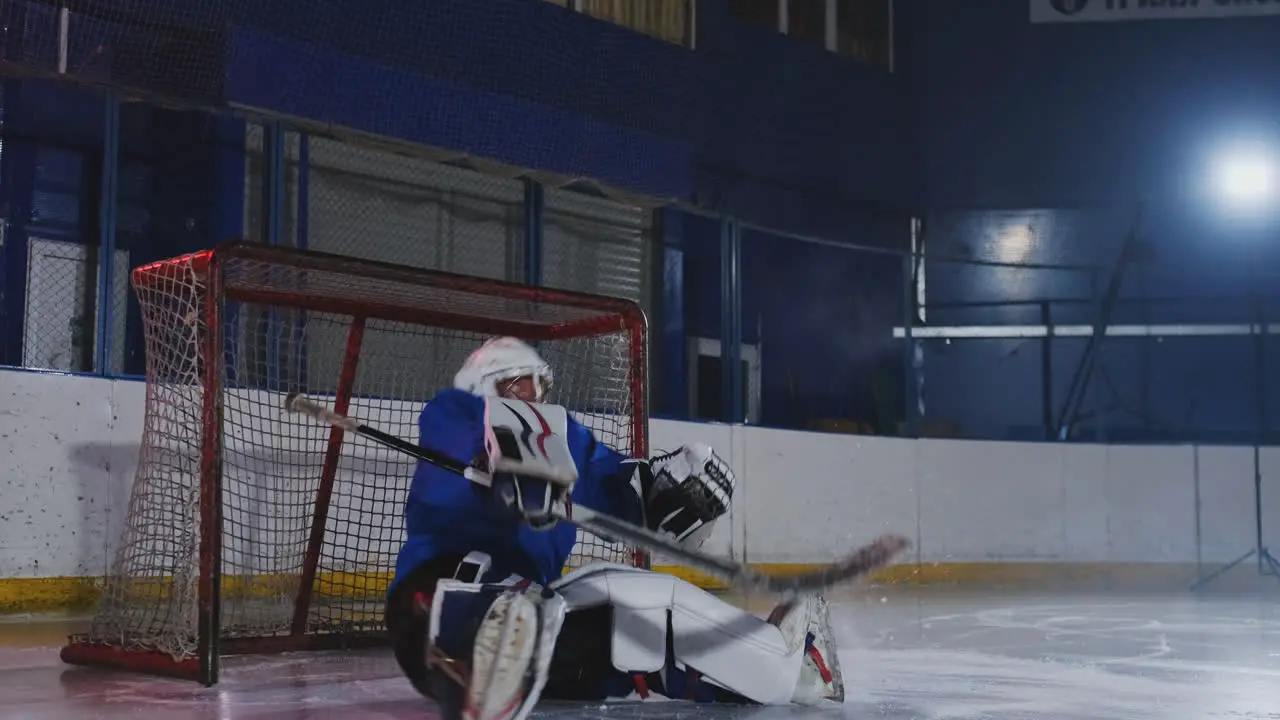 Hockey player conducts an attack on the opponent's goal Lying in a helmet catches the puck and saves the match Hockey player man of the match