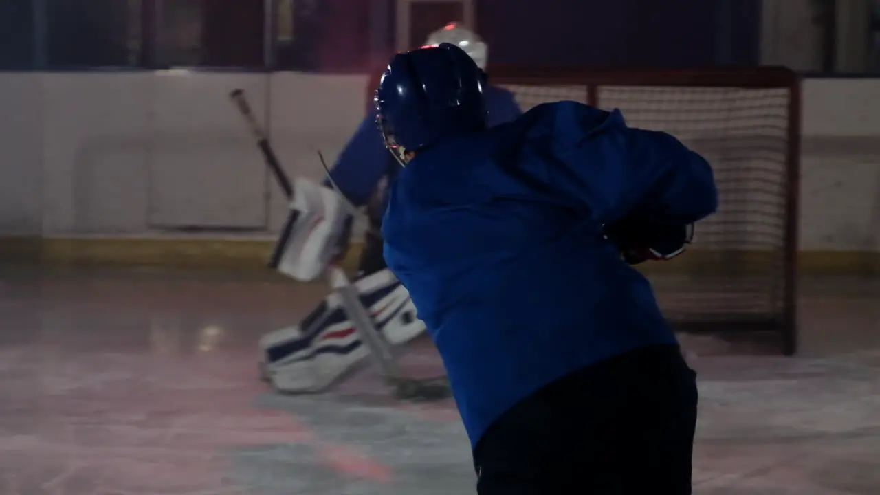 Professional athlete male hockey player turns in front of the camera with a puck and strikes the opponent's goal and scores