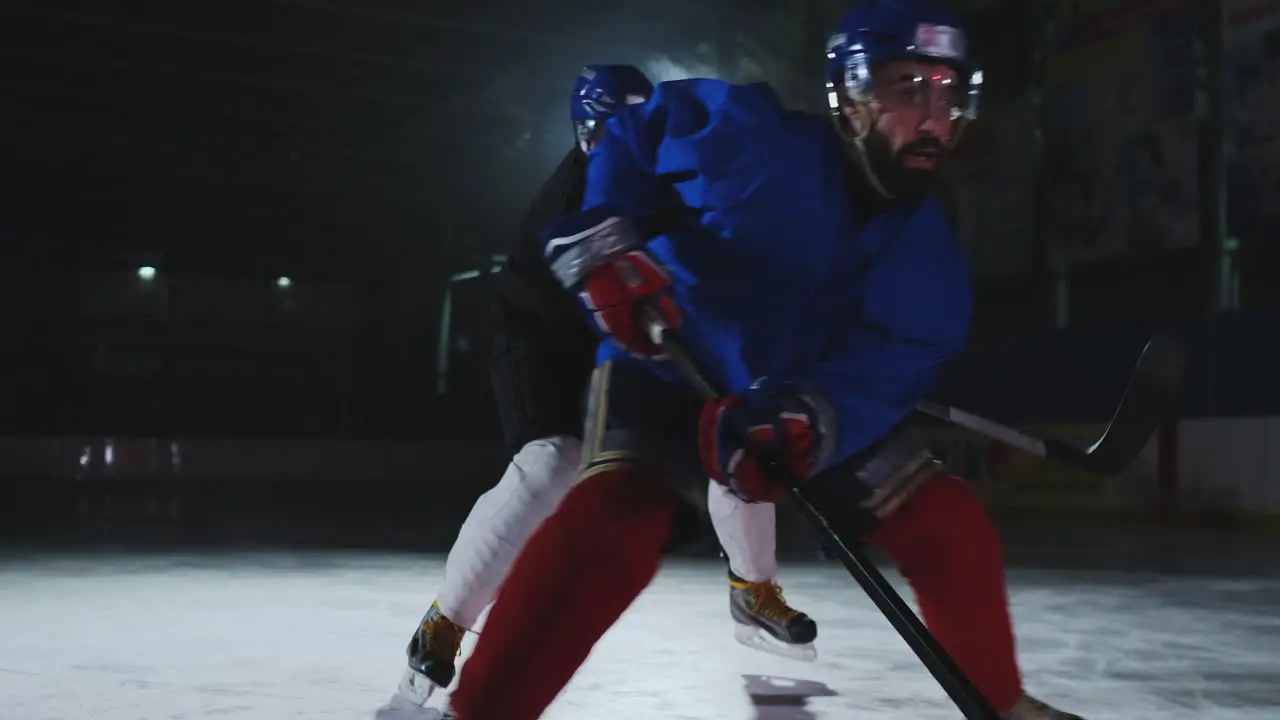 Two man playing hockey on ice rink hockey Two hockey players fighting for puck STEADICAM SHOT