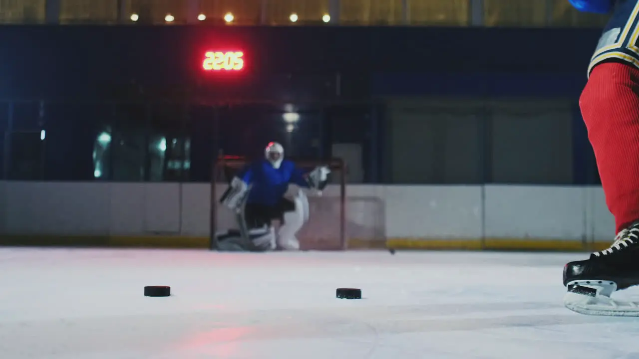 Close-up of a hockey puck in slow motion and a putter of several pucks in turn and a goalkeeper in the background