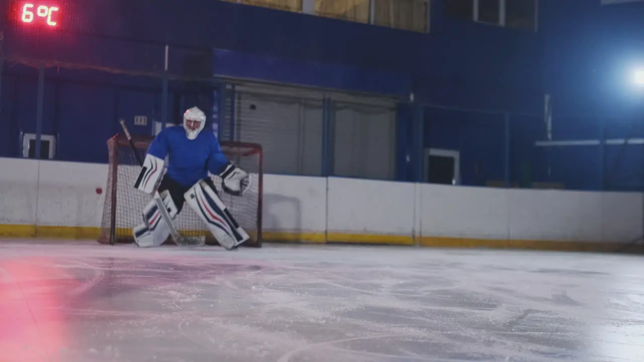 Professional hockey goalkeeper catches the puck after hitting a player in a hockey match