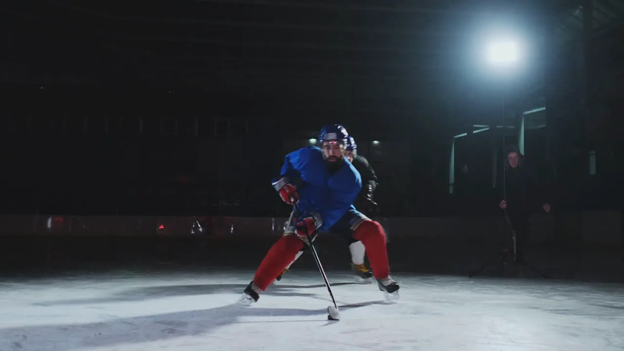 Two professional hockey men fighting for the puck on the ice arena using force techniques