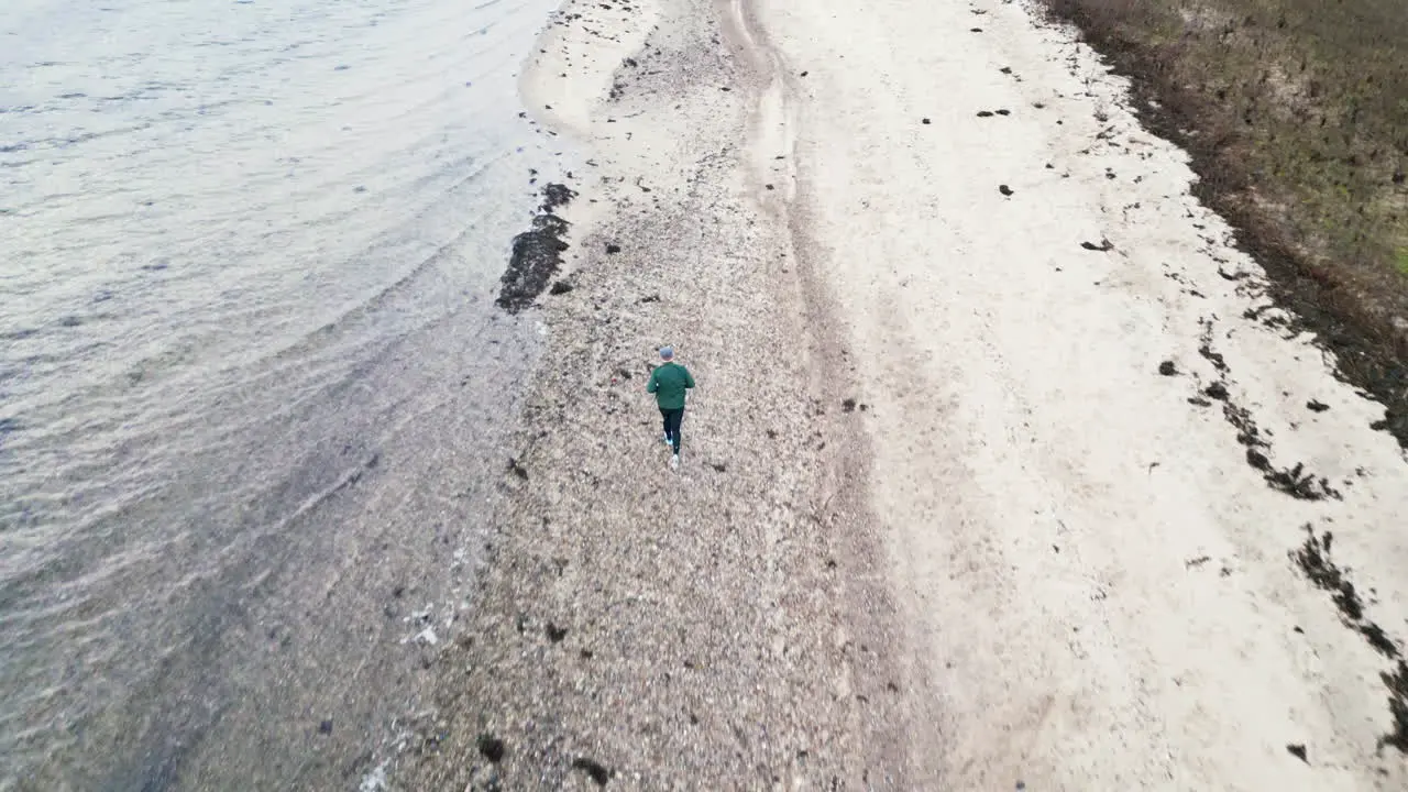 Aerial view of jogger on beach path on a overcast day