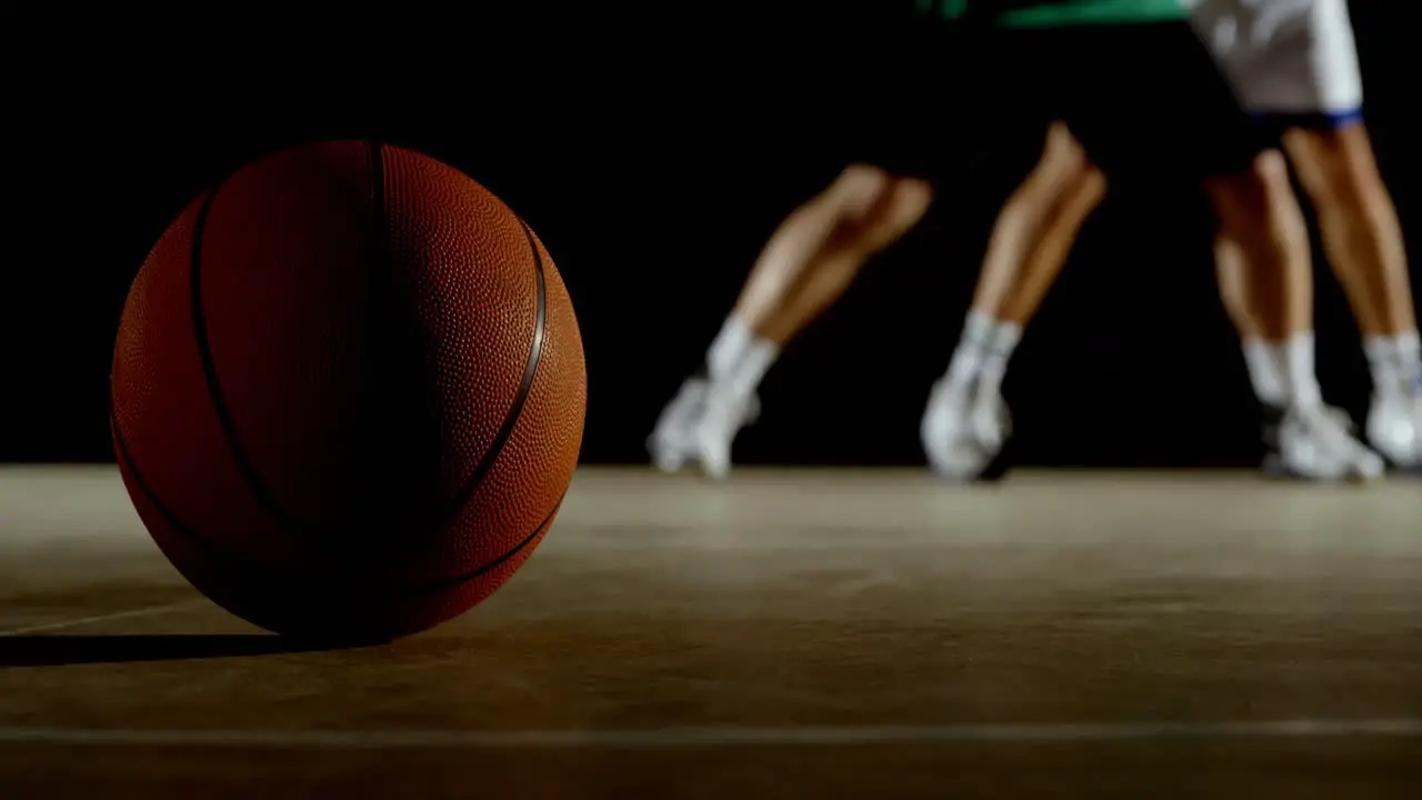 Basketball in the court while players playing basketball in the background 4k