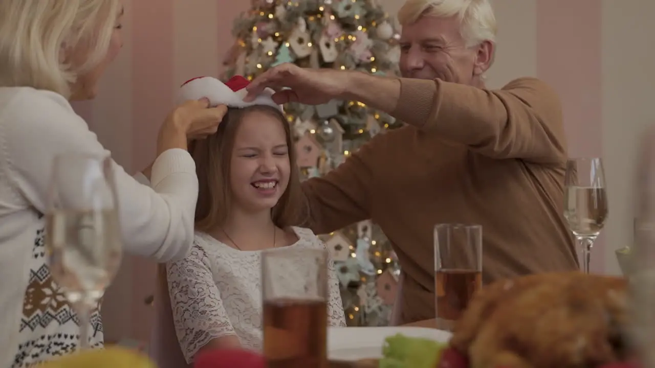 Grandparents Put Santa Hat On Their Granddaughter