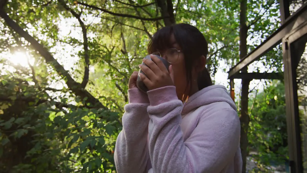 Asian girl drinking tea in garden and smiling