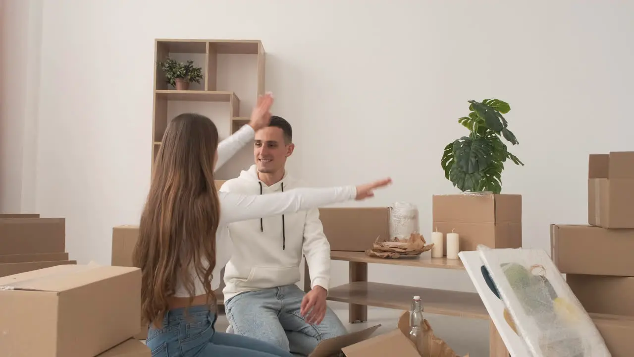 Zoom Out Shot Of Happy Couple Moving House Packing Their Belongings And Hugging