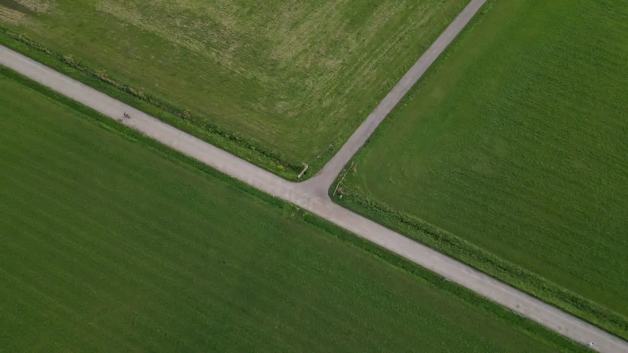 A cyclist riding a bike through green fields