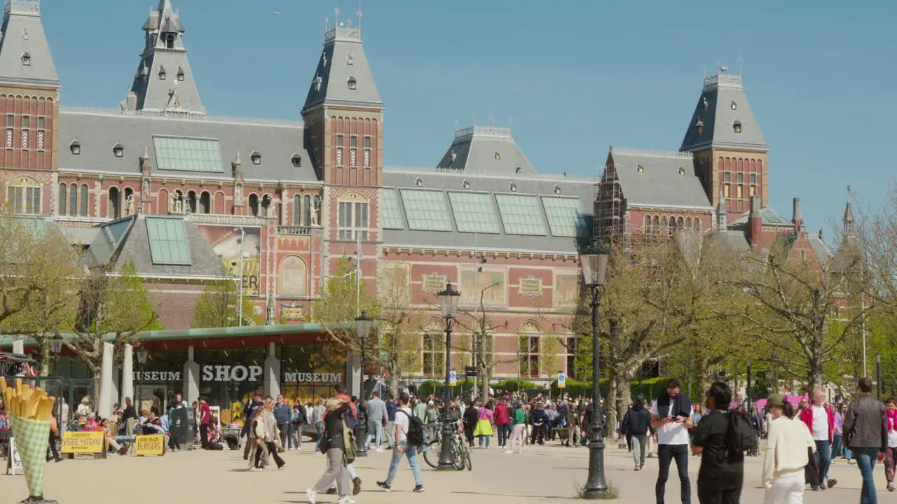 Vibrant Rijksmuseum Square Tourists Walking in Front of Beautiful Historic Museum in Amsterdam Netherlands Bathed in Sunlight