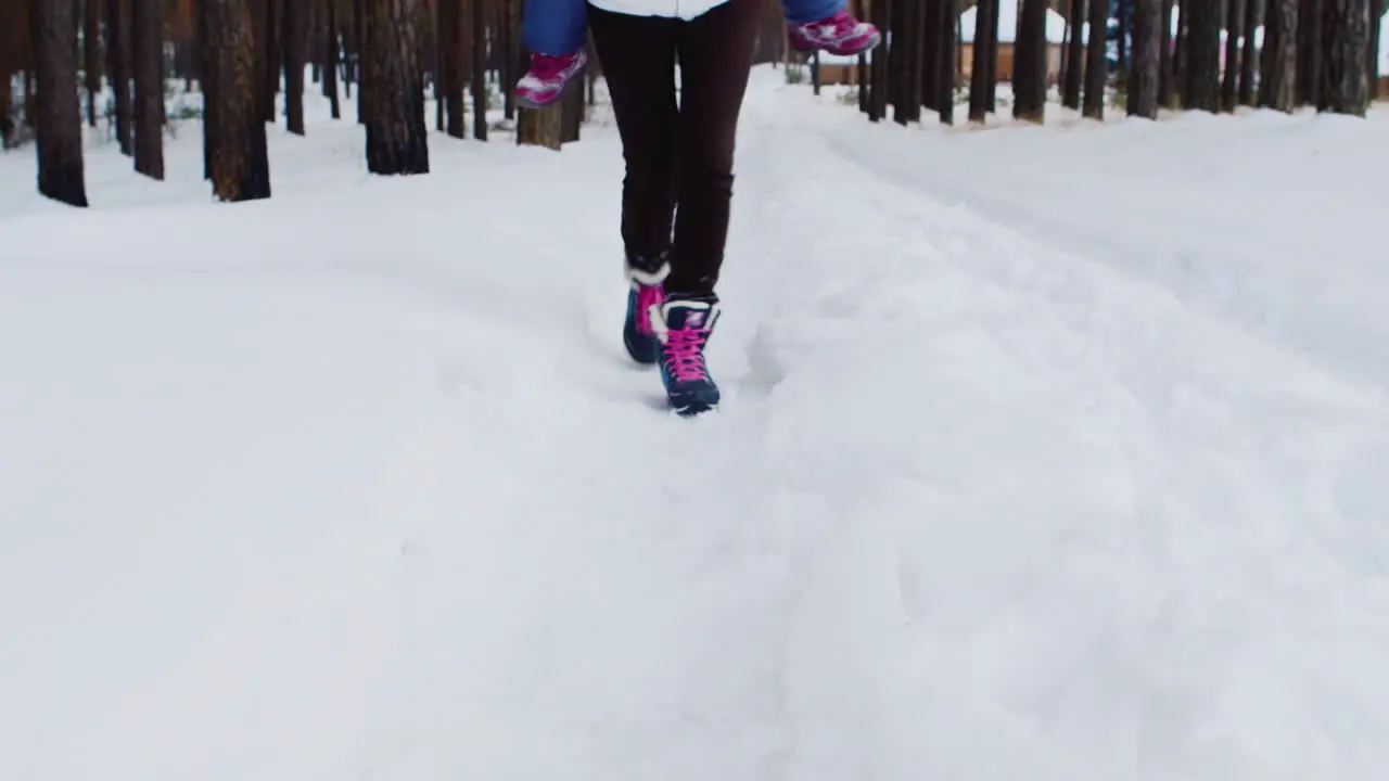 Mother Carries He Daughter Playfully Through Snowy Woods