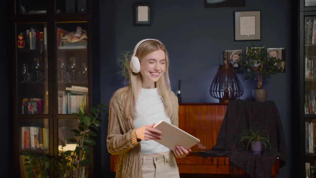 Mujer Joven Feliz Con Auriculares Escuchando Música En Tableta Y Bailando En La Sala De Estar En Casa