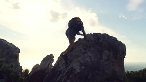 Hombre Llegando A La Cima De Una Montaña Contra La Puesta De Sol