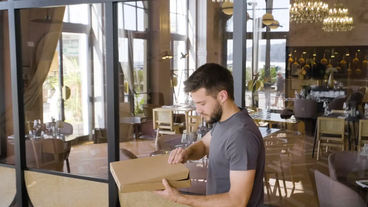 Hombre Abriendo La Caja De Cartón Para Revisar La Pizza Y Luego Saliendo Del Restaurante