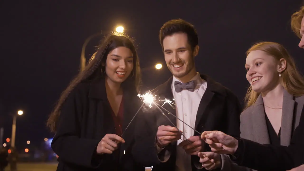 Grupo De Amigos Con Ropa Elegante Encendiendo Bengalas En La Calle Después De La Fiesta De Año Nuevo