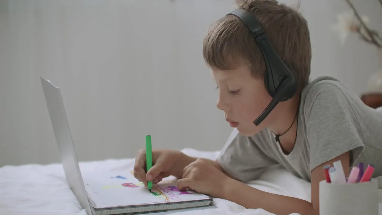 El Niño De La Escuela Está Descansando En Casa Durante Las Vacaciones Dibujando Y Viendo Videos Con Una Computadora Portátil Sentado Solo