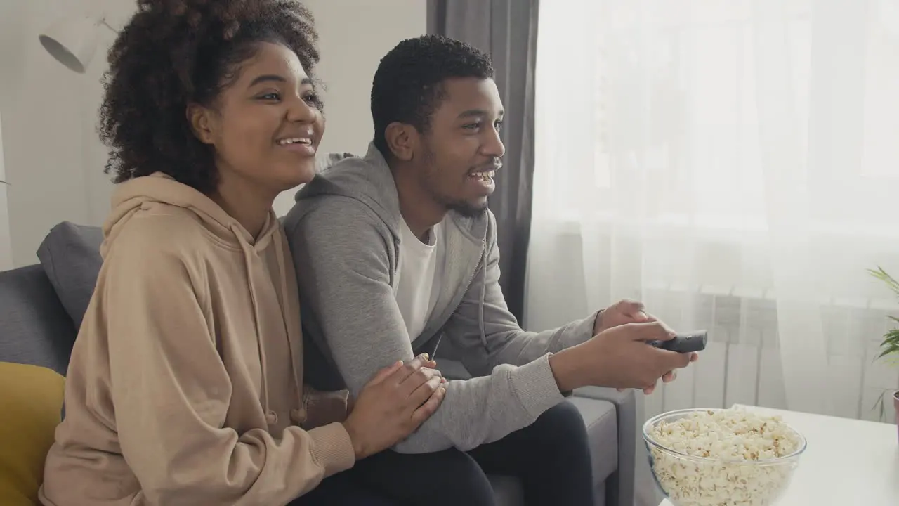 Pareja Joven Eligiendo Una Película Con El Control Remoto