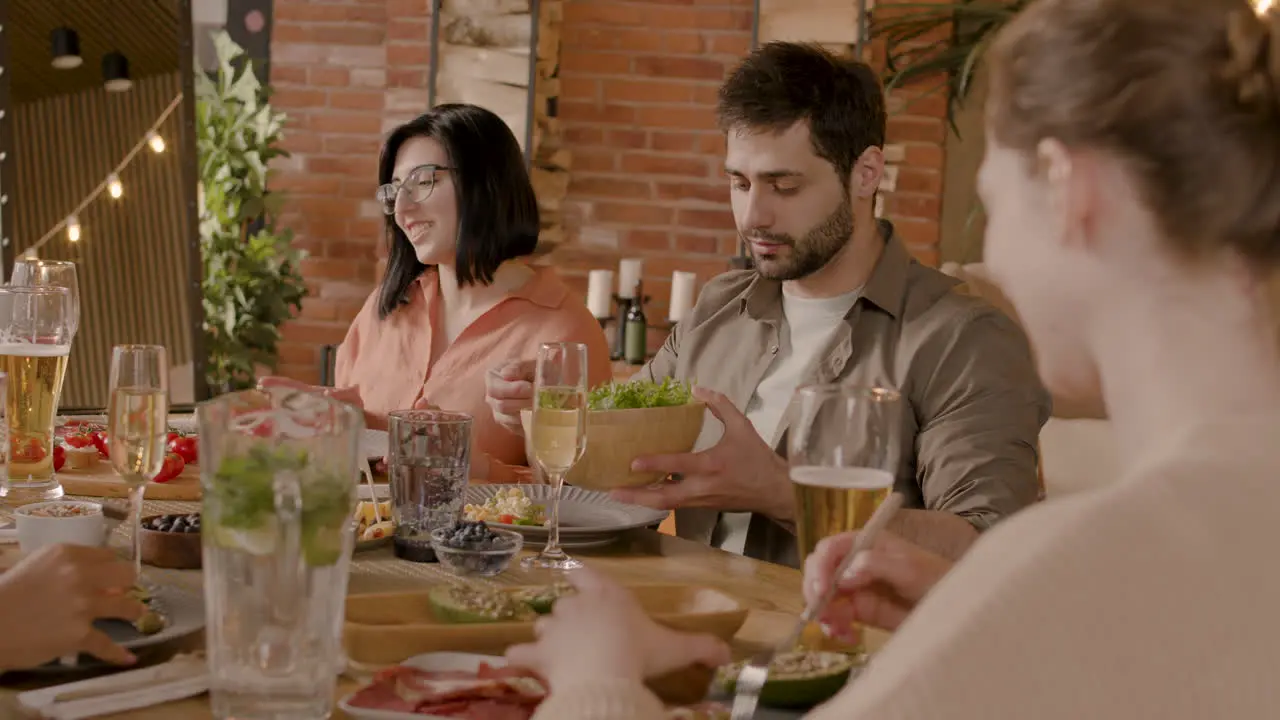 El Joven Se Sirve Una Ensalada En Una Cena