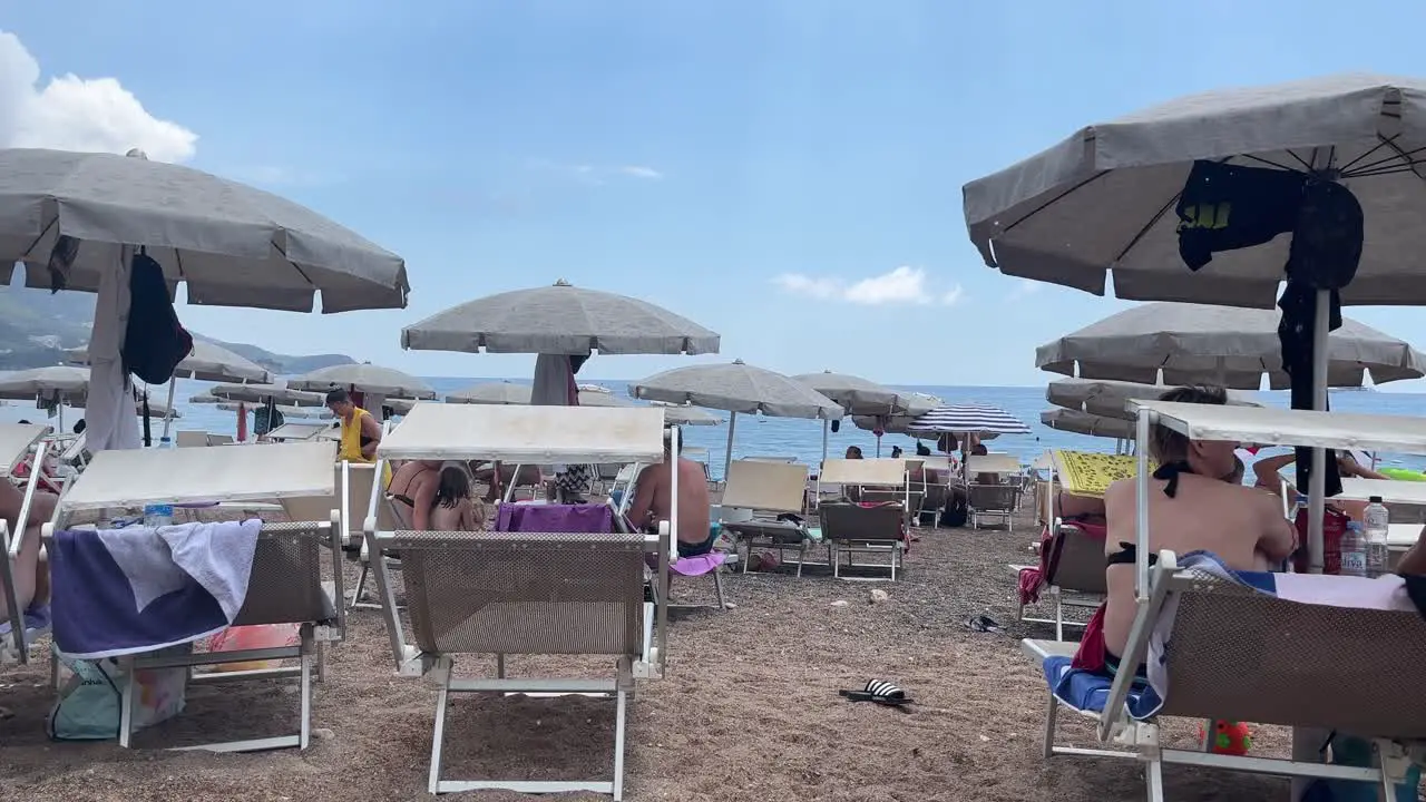 Sunshine and rain on a beach in montenegro lots of tourists in a lovely location