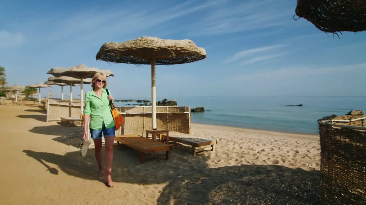 Steadicam Shot Tourist With A Beach Bag Walking Down The Beach