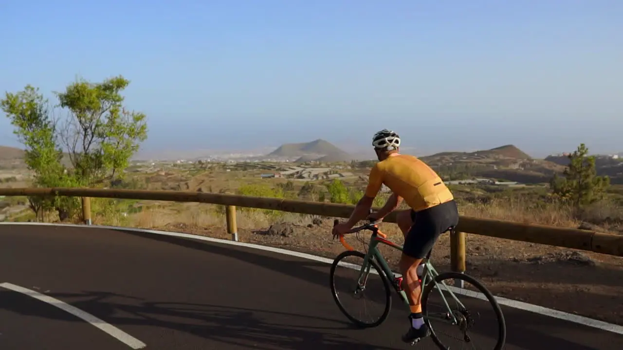 Tracking-Videoaufnahme Eines Männlichen Radfahrers Der Eine Bergstraße Hinaufsteigt Mann Beim Radtraining Auf Einer Hügeligen Autobahnstraße An Einem Sonnigen Tag