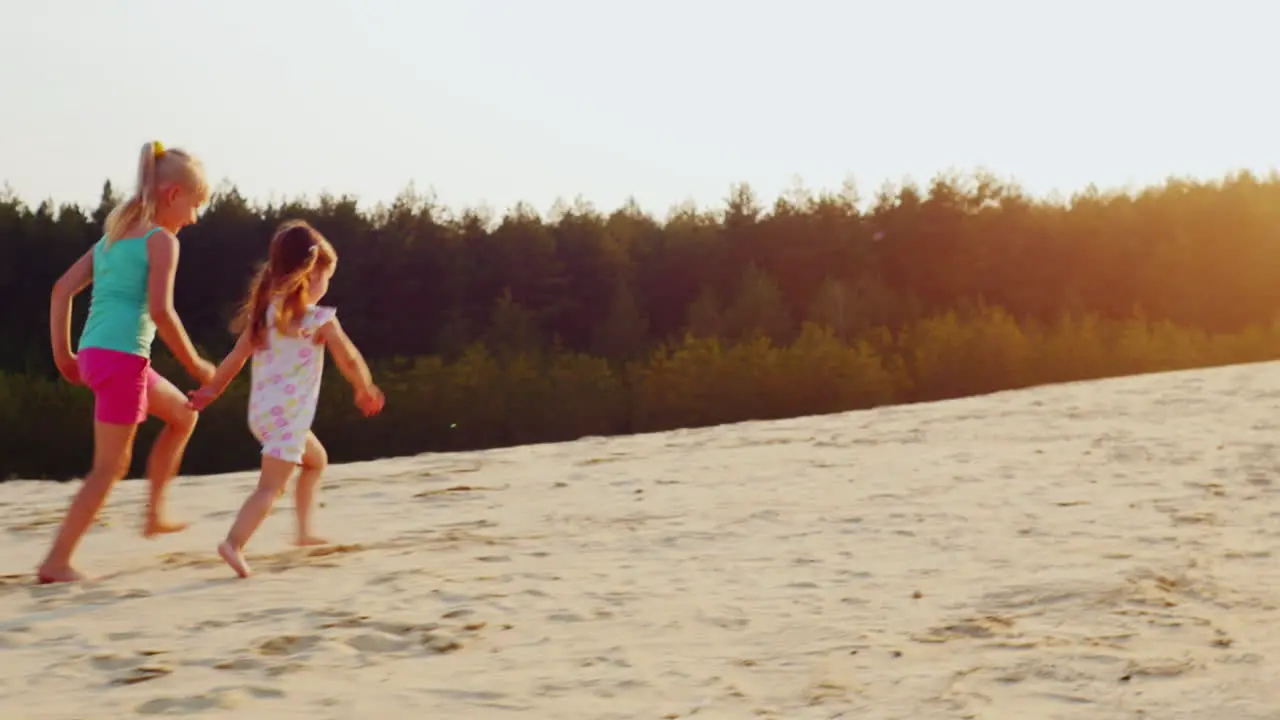 Two Cheerful Girl Running A Race On The Sand At Sunset Children's Games A Happy Childhood Prores Hq 