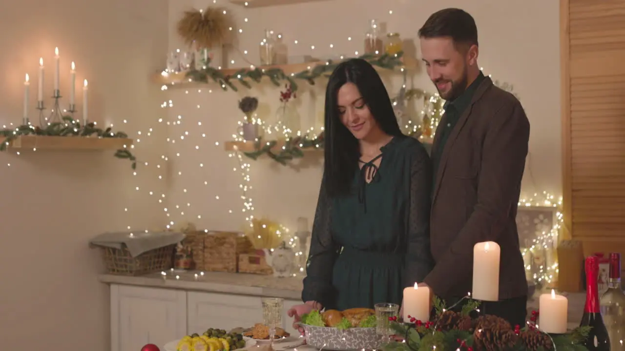 Pareja Elegante Poniendo Pollo Asado En La Mesa De La Cena De Navidad