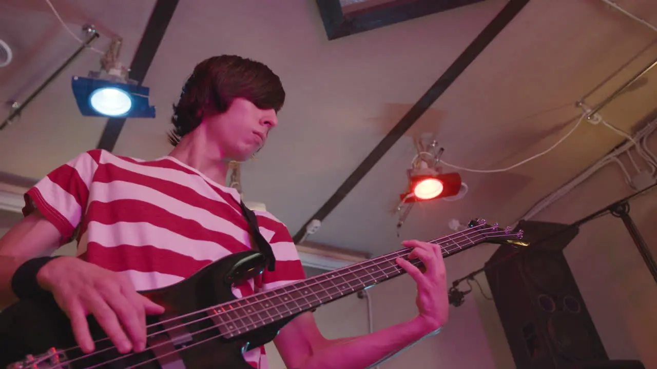 Niño Enérgico Tocando La Guitarra Durante Un Ensayo De La Banda En El Estudio De Grabación 3