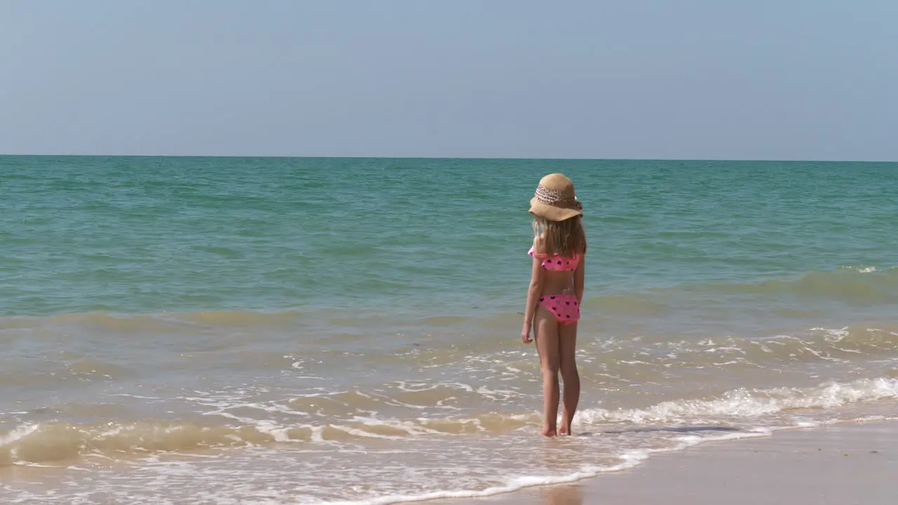 Young bikini girl standing on tropical beach