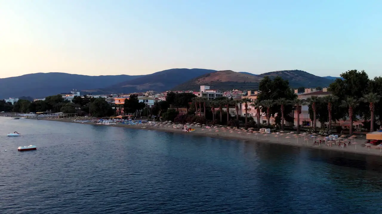 Aerial side flight from seaside through coastline and summer houses Balikesir Turkey