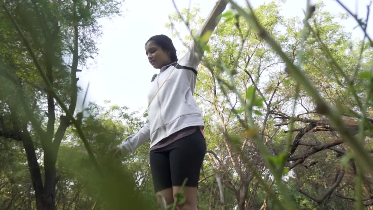 Athletic Beautiful Woman Exercises with Jump Skipping Rope in the forest