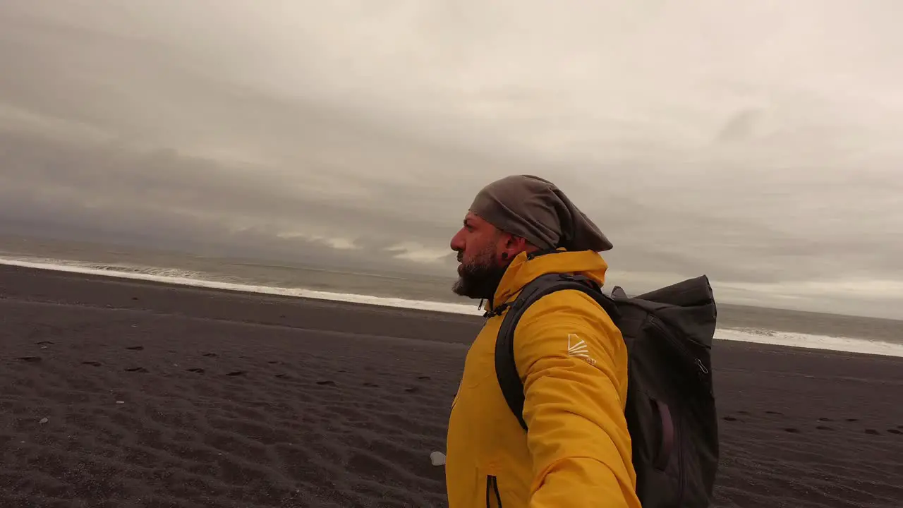 a man walking along Reynisfjara Black Sand Beach