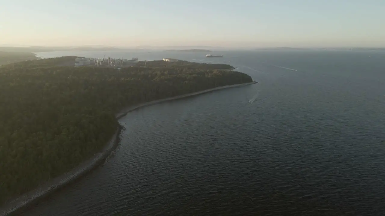 Coastline in Southern Norway oil refinery and cargo ship in a far