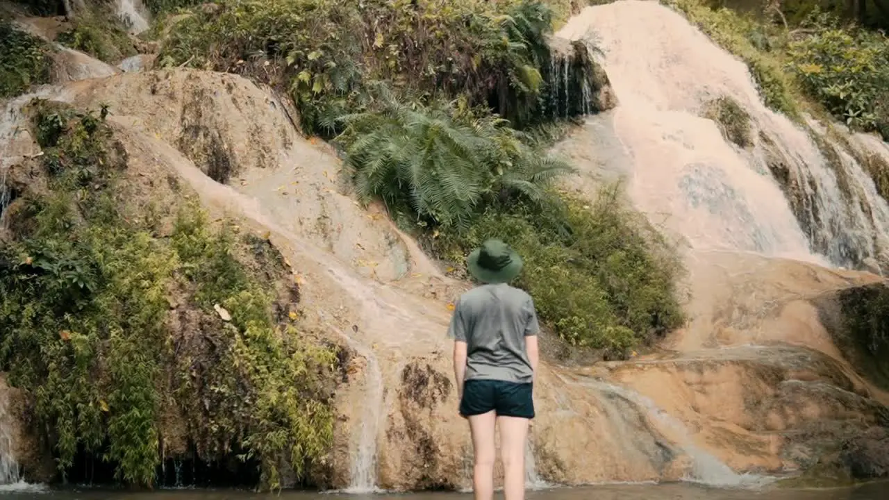 Back of young person standing in beautiful nature and water landscape