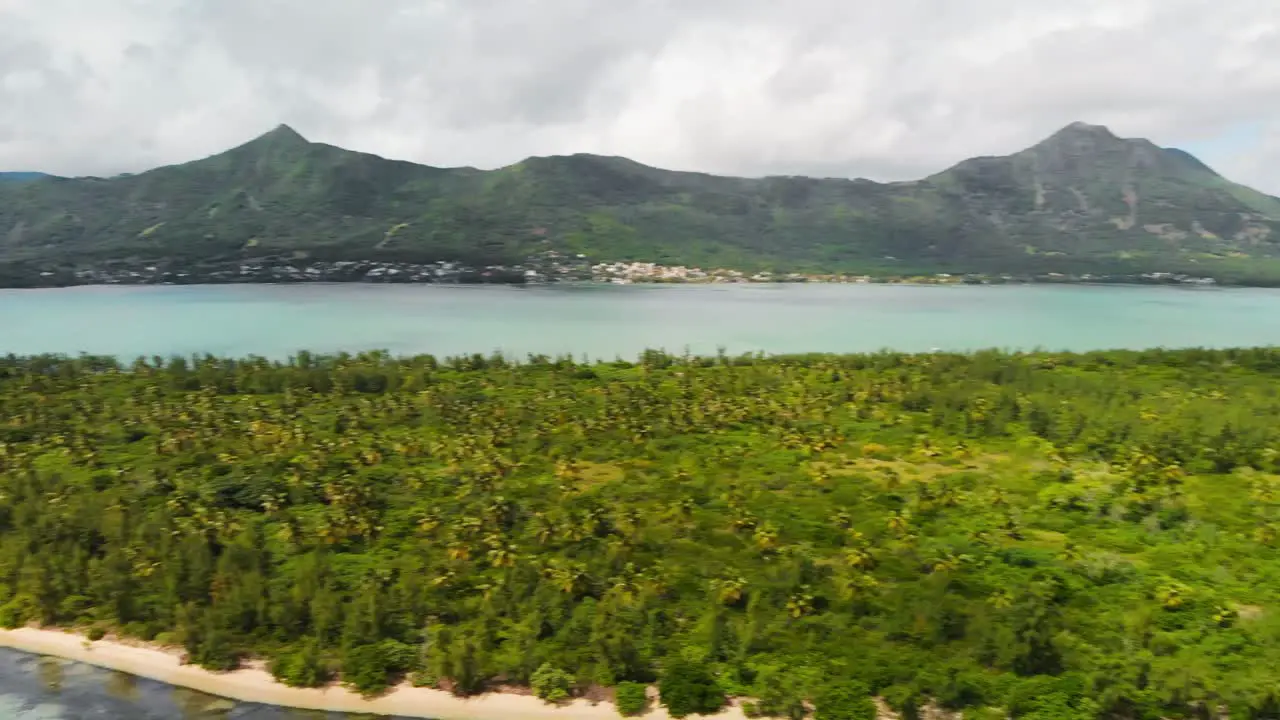 Panning shot of the Ile Aux Benitiers in Mauritius with mountains in the background